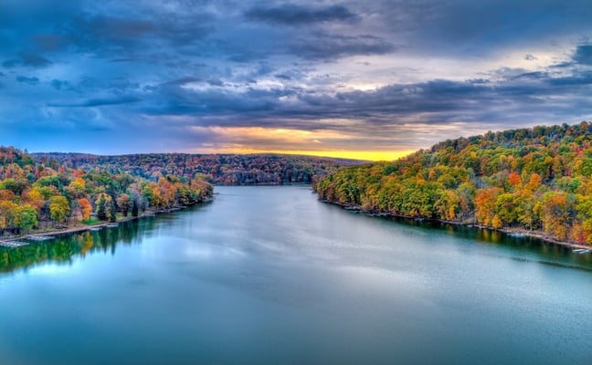 Aerial view of Deep Creek Lake at sunset with autumn foliage lining both shores