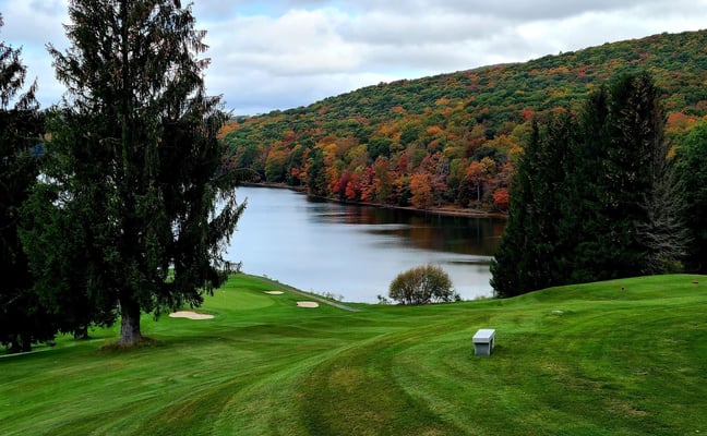 Alpine Lake golf course fairway with autumn foliage and the lake visible through the trees