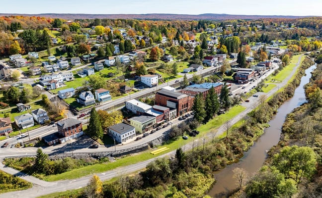 Aerial view of Thomas, WV downtown along the river with autumn foliage on the surrounding hills